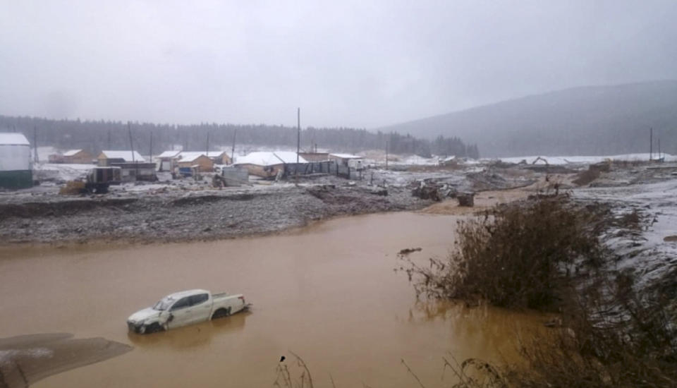 In this image made from video provided by Russian Emergency Situations Ministry press service, a view after the collapse during heavy rain occurred early Saturday near the village of Shchetinkino, in the Krasnoyarsk region about 3,400 Km (2,100 miles) east of Moscow, Russia, Saturday, Oct. 19, 2019. Russian emergency officials say at least 15 people are dead after a dam at a Siberian gold mine collapsed and water flooded two workers' dormitories,13 people were unaccounted for, Russian news agencies reported. (Russian Ministry of Emergency Situations press service via AP)