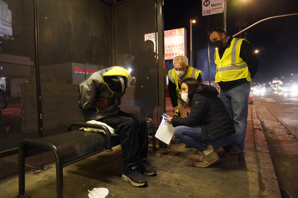 Los Angeles city councilmember Paul Krekorian, third from right, talks to a homeless man during a city-wide count, with members of his staff Lorraine Diaz, kneeling, and Karo Torossian Tuesday, Feb. 22, 2022, in the North Hollywood section of Los Angeles. Los Angeles County has resumed its annual homeless count in full a year after it was limited over concerns that it couldn't be done safely or accurately during the coronavirus pandemic. (AP Photo/Marcio Jose Sanchez)