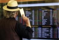 A man looks at an electronic board displaying stock index outside a bank in downtown Milan June 13, 2013. REUTERS/Alessandro Garofalo