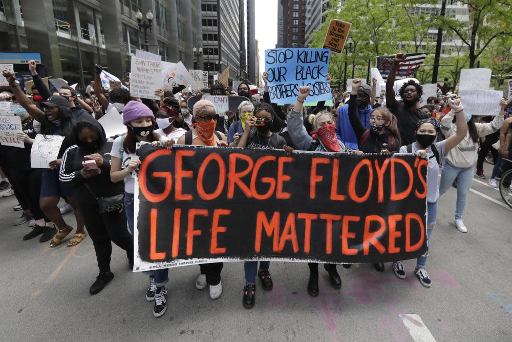 Protesters hold signs as they march during a protest over the death of George Floyd in Chicago on May 30, 2020. (AP Photo/Nam Y. Huh, File)