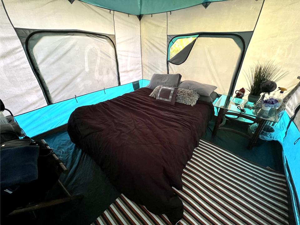 Glamping tent in Hawaii with a queen sized bed and bedside table