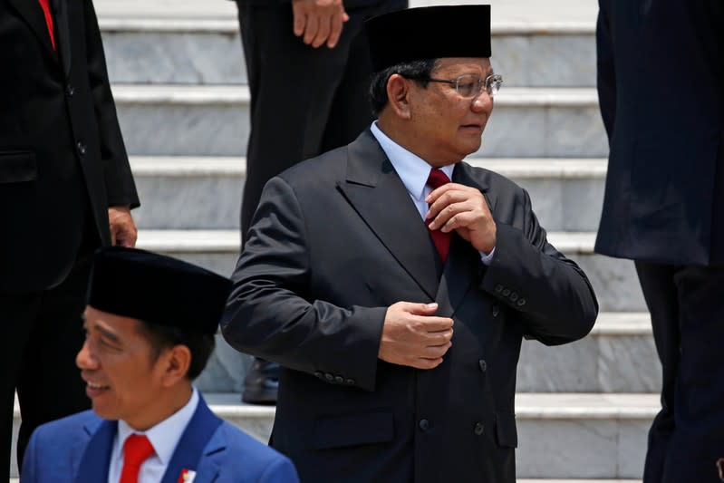 Newly appointed Indonesian Defense Minister Prabowo Subianto, who was the former rival of Indonesian President Joko Widodo in April's election, prepares before taking group photos after his inauguration at the Presidential Palace in Jakarta