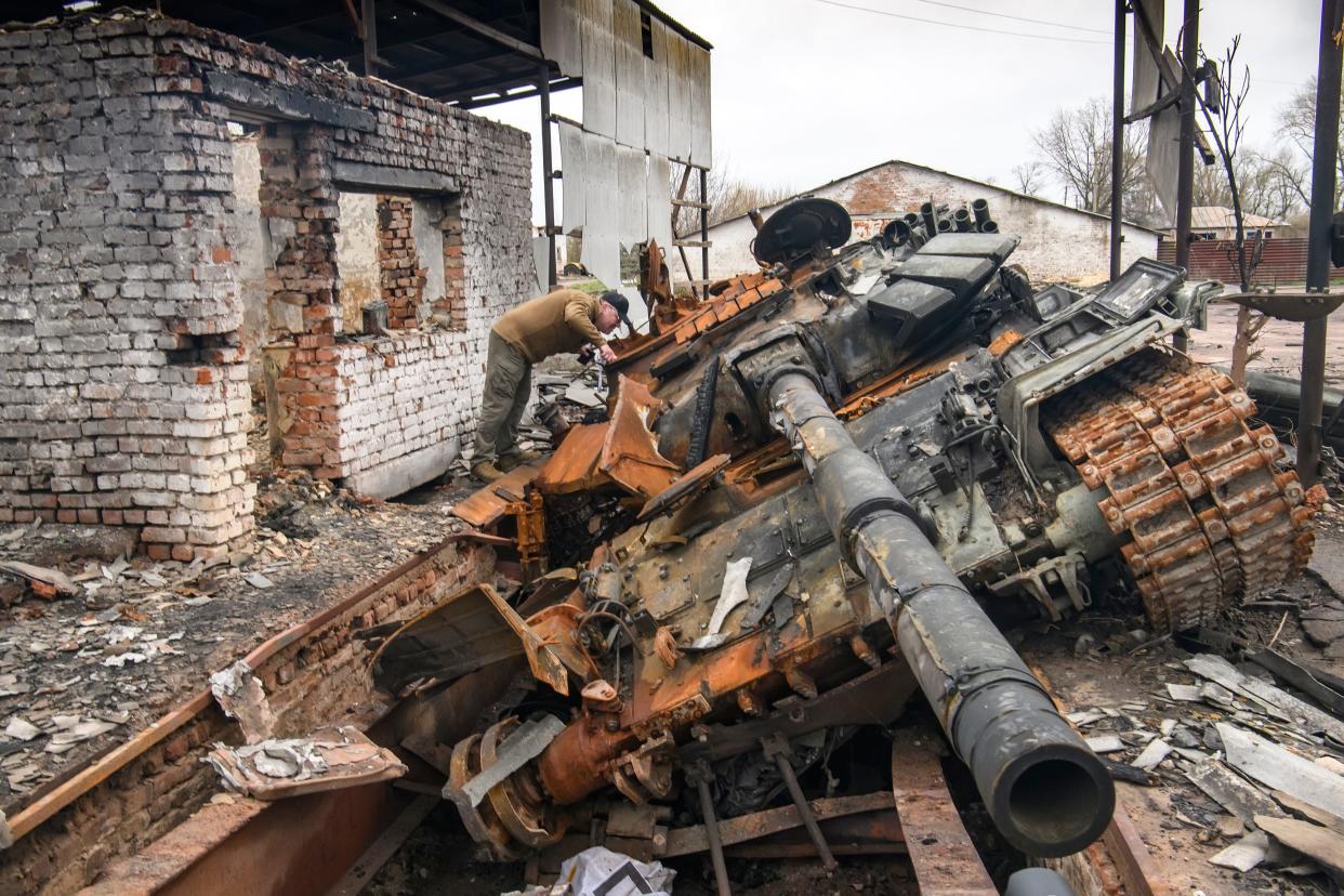 A man looks at russian T-72 tank destroyed during Russia's invasion to Uktaine, Ivanivka village, Chernihiv area, Ukraine, on April 20, 2022.