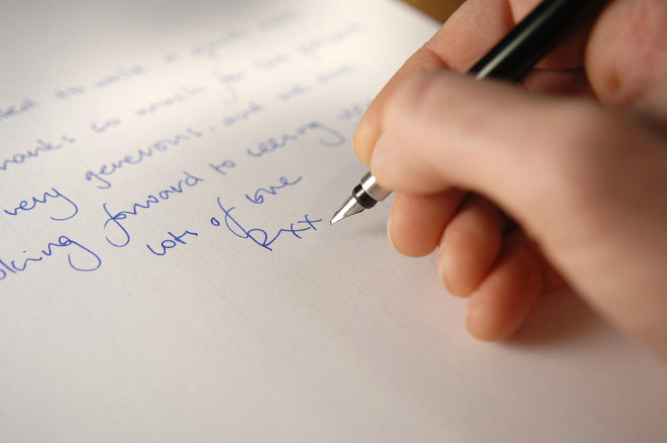 A person writing a letter