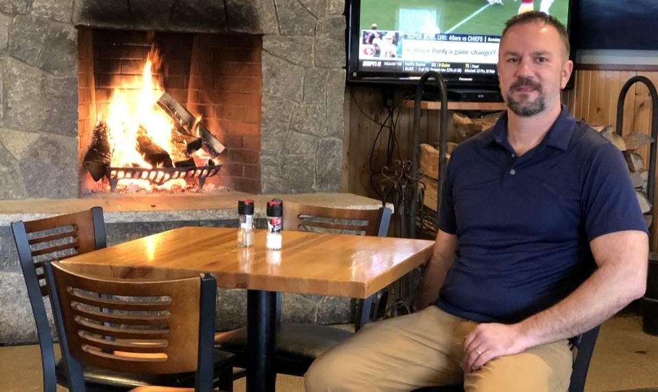 Ian Miller is one of the new co-owners of the New England House Seafood and Sports Bar on Post Road in Wells, Maine. He is seen here by the dining room's roaring fire, shortly before the restaurant opened for the day on Thursday, Feb. 8, 2024.