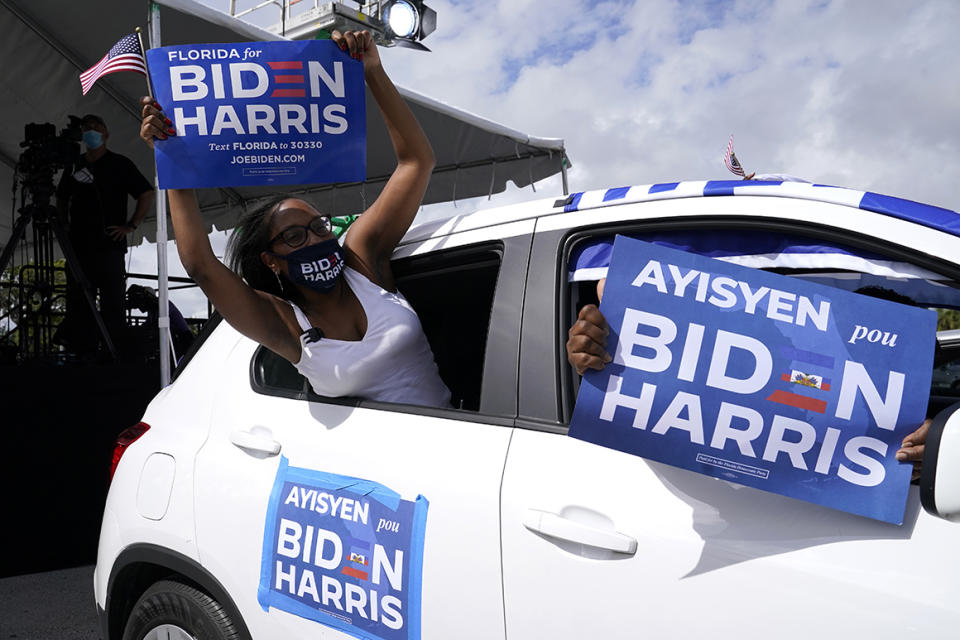 Nashley Harrigan, who is of Haitian descent, cheers from her vehicle at a car rally before a speech by former President Barack Obama who is campaigning for Democratic presidential candidate former Vice President Joe Biden at Florida International University, Saturday, Oct. 24, 2020, in North Miami, Fla. (AP Photo/Lynne Sladky)