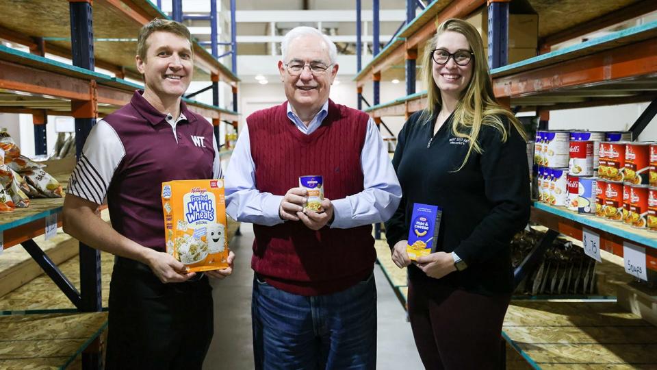 Simon Leech, center, president of St. Helen's Outreach, and WT Alumni Association Executive Director Ronnie Hall, left, and Assistant Director Abby Waters hope that the community will help fill the shelves at The Market on Tierra Blanca during a holiday food drive.