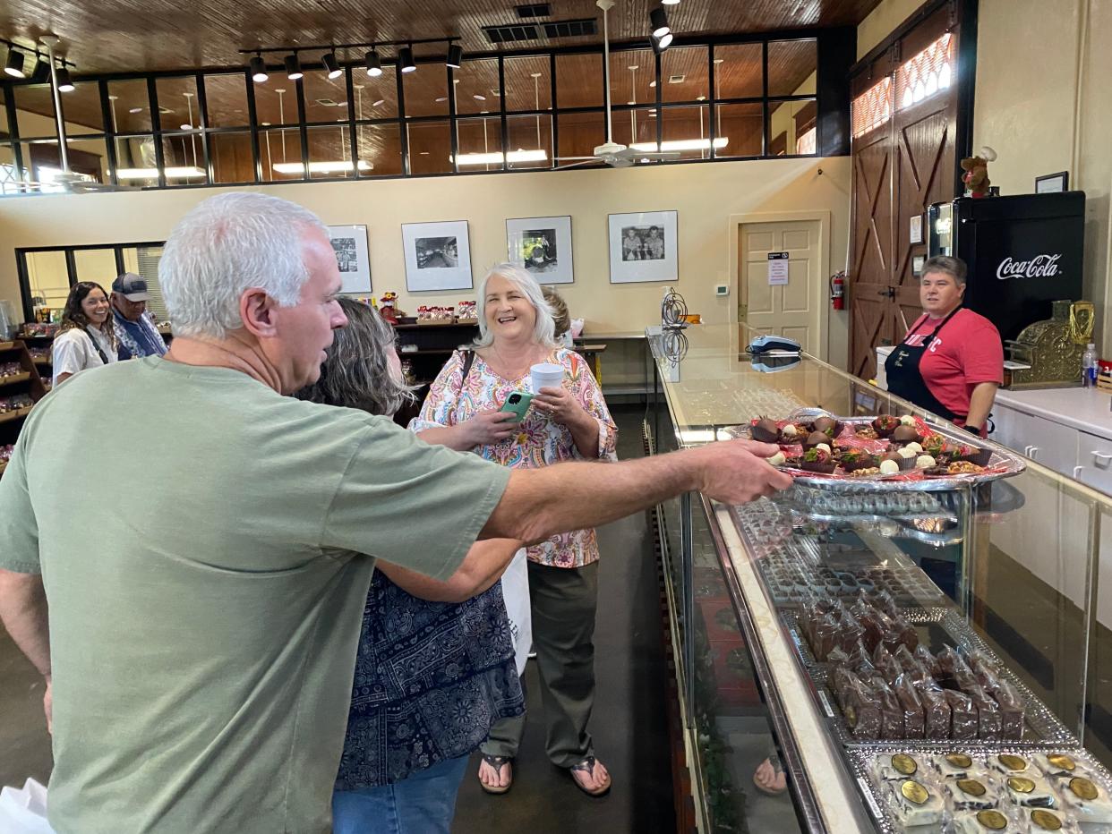 Tourists enjoy samples at Candies by Vletas during the Downtown Abilene Walking Tour. Tour guide Trevor Allen collaborates with local downtown businesses to bring guests into their stores.