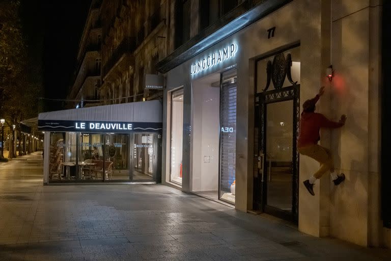 Un miembro del colectivo On The Spot Parkour salta por la pared de un negocio cerca de los Campos Elíseos, en París.  (Mauricio Lima/The New York Times)