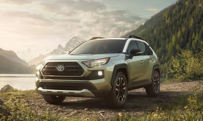 A silver Toyota RAV4, a compact crossover SUV, parked next to a lake