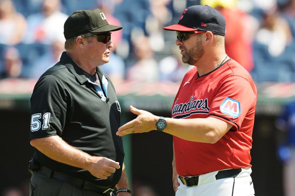 Cleveland Guardians manager Stephen Vogt (12) talks with umpire Marvin Hudson on Aug. 26 in Cleveland.