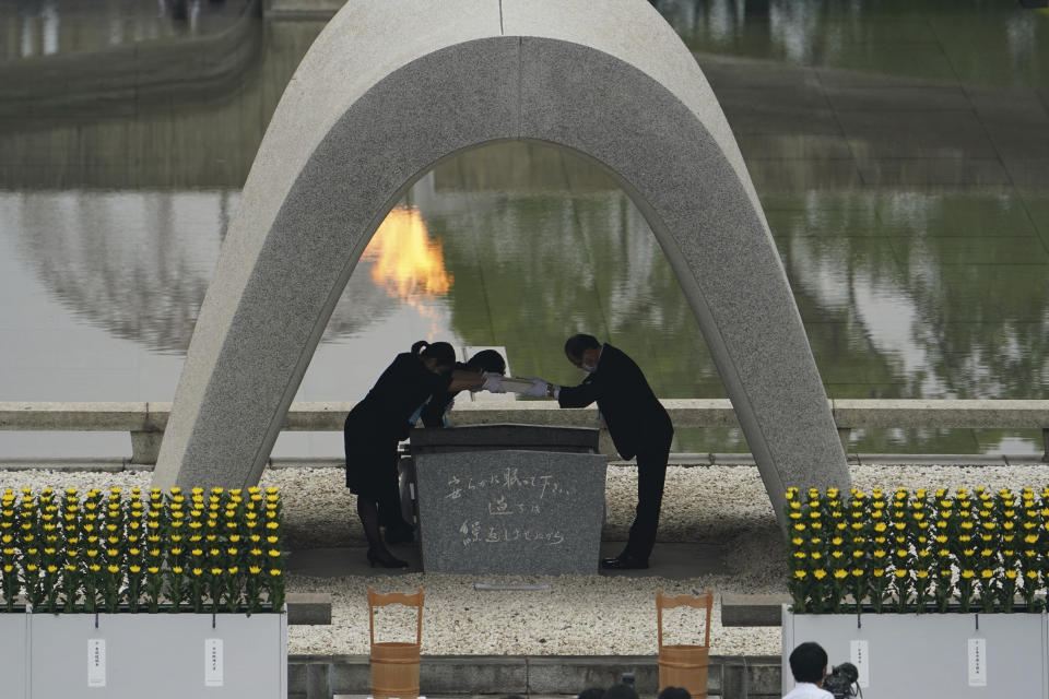 Kazumi Matsui, right, mayor of Hiroshima, and the family of the deceased bow before they place the victims list of the Atomic Bomb at Hiroshima Memorial Cenotaph during the ceremony to mark the 75th anniversary of the bombing at the Hiroshima Peace Memorial Park Thursday, Aug. 6, 2020, in Hiroshima, western Japan. (AP Photo/Eugene Hoshiko)