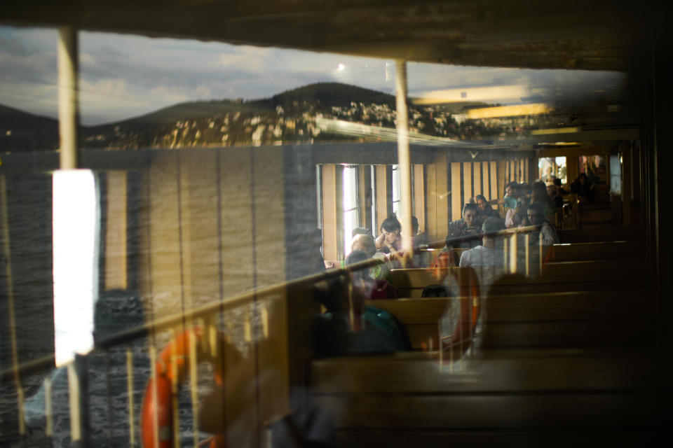 People take a ride in a ferry crossing the Bosphorus strait in Istanbul, Turkey, Sunday, June 12, 2022. (AP Photo/Francisco Seco)