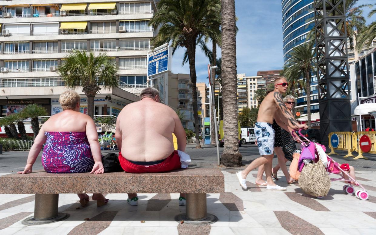 Overweight British holidaymakers sunbathing on the waterfront in Benidorm, Costa Blanca, Spain - Getty Images