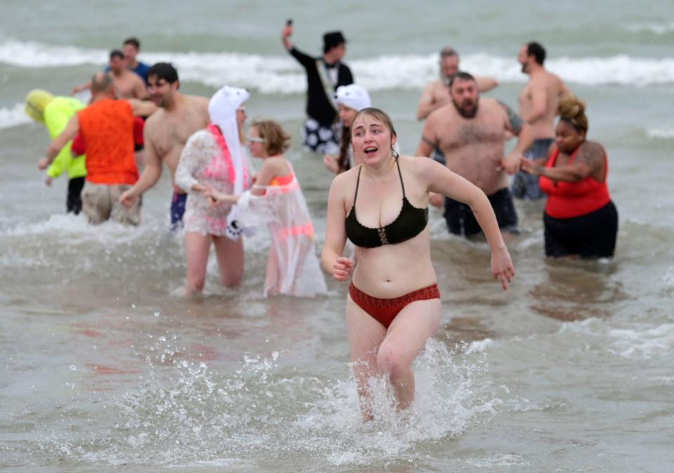 A woman reacts as she is one of the first to return to dry land during the 51st Sheboygan Polar Bear Plunge, Friday, January 1, 2021, in Sheboygan, Wis.