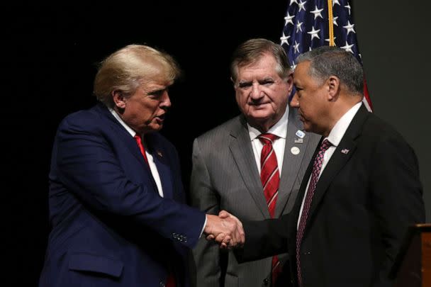 PHOTO: Newly announced Chairman of the N.H. GOP Chris Ager, right, shakes hands with former President Donald Trump as outgoing N.H. GOP Chairman Stephen Stepanek looks on, on Jan. 28, 2023, in Salem, N.H. (Reba Saldanha/AP)