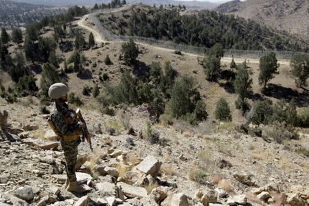 A soldier stands guard along the border fence at the Angoor Adda outpost on the border with Afghanistan in South Waziristan, Pakistan October 18, 2017. REUTERS/Caren Firouz