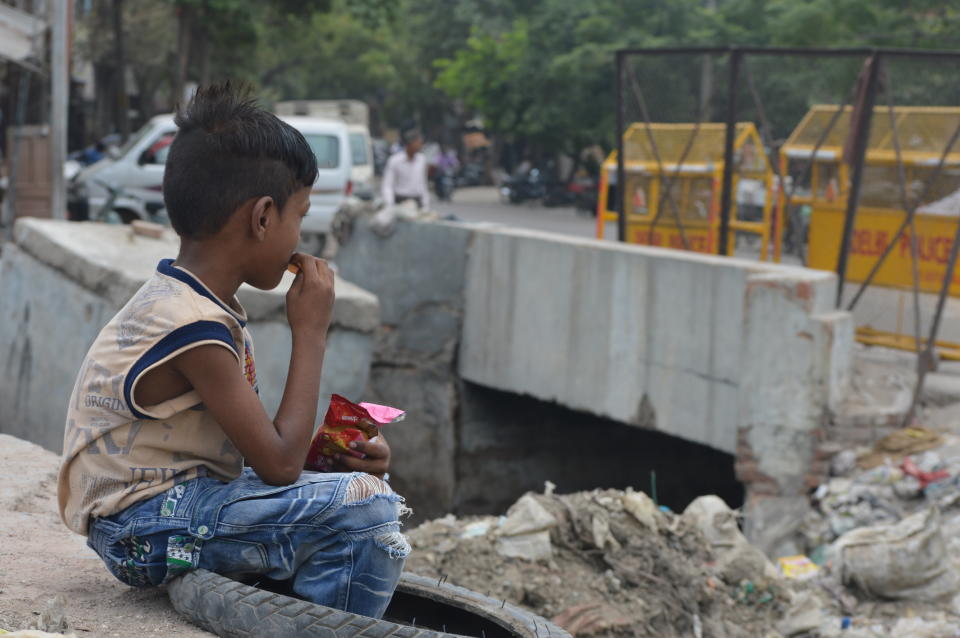 A child eating near a sewage canal at Kanti Nagar, New Delhi.&nbsp; (Photo: Athar Parvaiz)