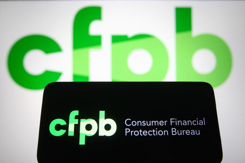 A phone screen with the Consumer Financial Protection Bureau and a larger CFPB in the background.