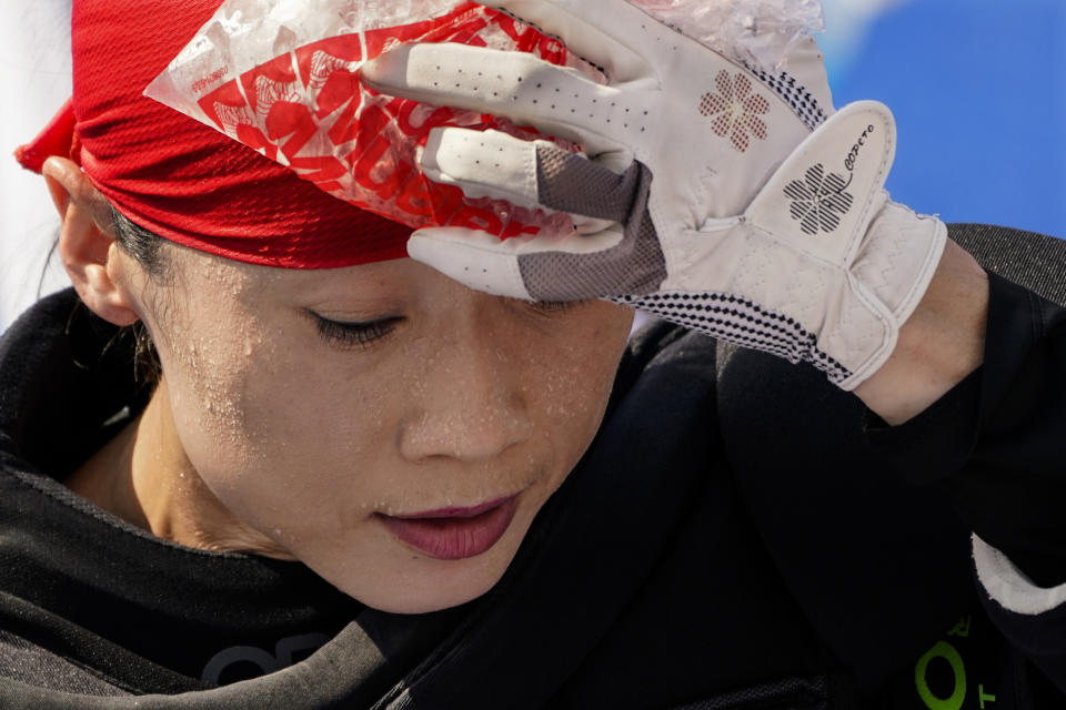 Beads of sweat gather on the face of China women's field hockey goalkeeper Dongxiao Li as she presses a bag of ice against her head during practice hours at the 2020 Summer Olympics, Friday, July 23, 2021, in Tokyo, Japan. (AP Photo/John Minchillo)