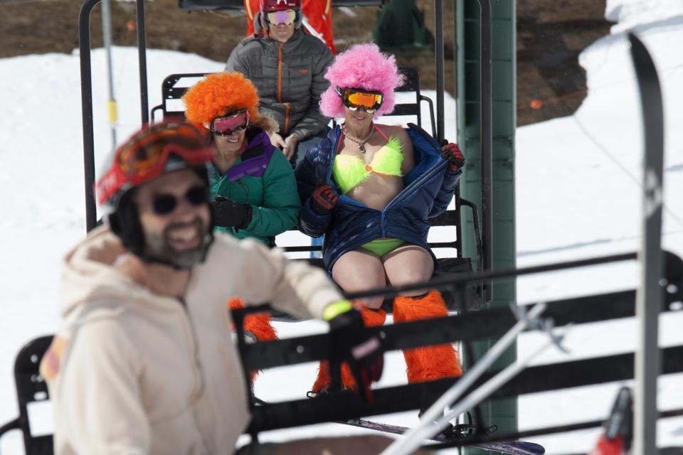 Skiers and snowboarders brave the cold while riding a chairlift during the Bikini & Board Shorts Downhill at Crystal Mountain, a ski resort near Enumclaw, Washington