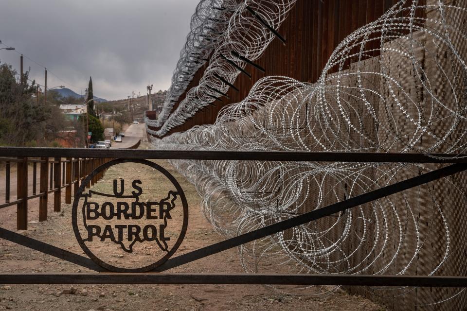 A metal fence marked with the U.S. Border Patrol insignia prevents people from getting close to the barbed/concertina wire covering the larger border fence in Nogales, Arizona, on Feb. 9, 2019. (Photo: ARIANA DREHSLER via Getty Images)