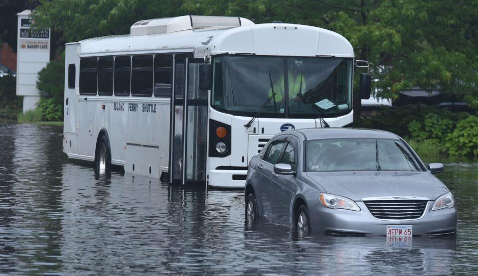Bus driver Elaine Thibeault looks out the front window as flood waters recede on Tuesday on Center Street in Hyannis. Thibeault said the water ran down Elm Street like a river, trapping several vehicles by the Hyannis Transportation Center. At one point she said, "I saw a bottle floating by and thought about putting a note in it."
