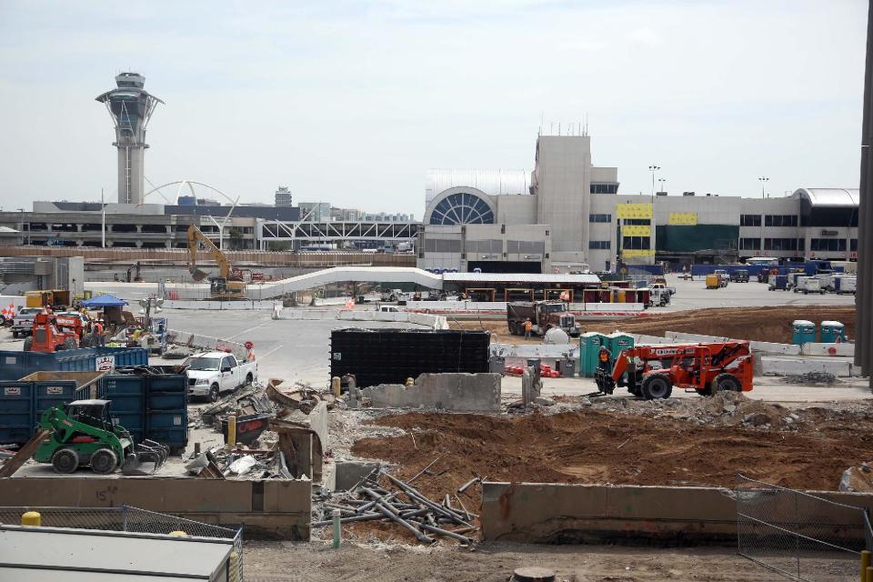 In this Monday, May 5, 2014 photo, construction crews work at Los Angeles International Airport (LAX). An ongoing, multibillion-dollar renovation at the nation's third-busiest airport that has mostly been behind the scenes will soon start affecting passengers in ways large and small. LAX officials began warning the public about the coming inconveniences that will stretch over the next few years and affect traffic around the terminals and passenger movements inside them. (AP Photo/Nick Ut )