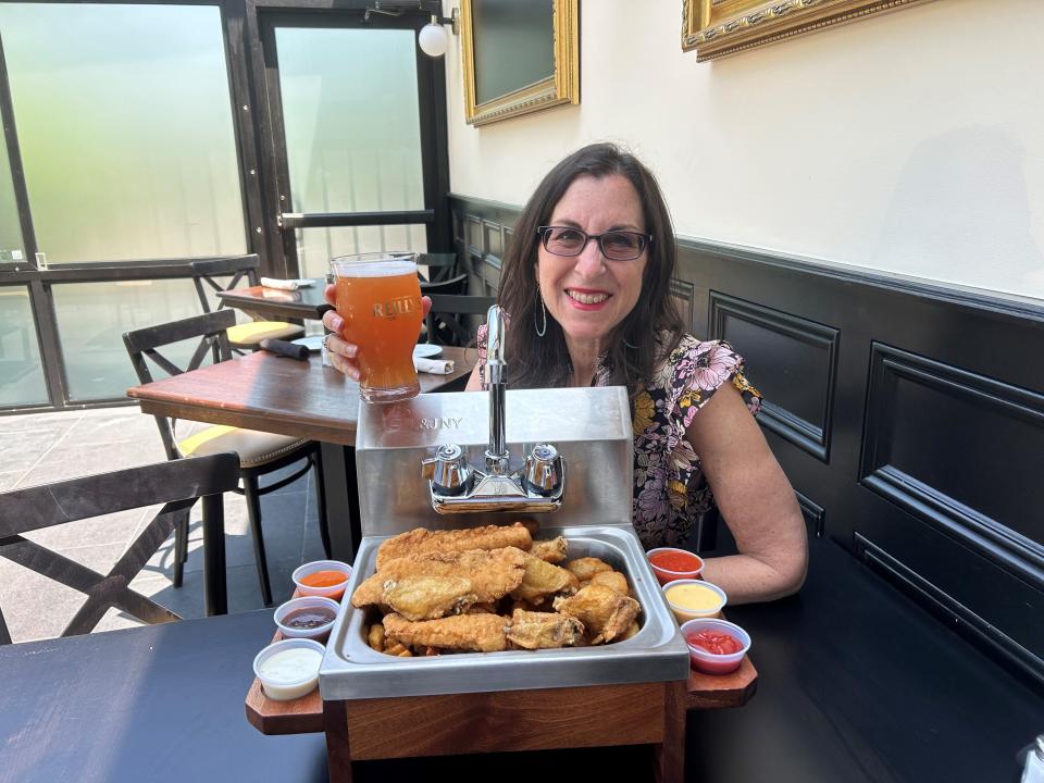 Lohud Food & Dining Reporter Jeanne Muchnick enjoys the "Everything but the Kitchen Sink" at Reilly's Public House in Piermont. The bar snack, which easily feeds three, is filled with wings, chicken tenders, waffle fries and mozzarella sticks and is Muchnick's "Best Thing I Ate This Week". Photographed June 2023