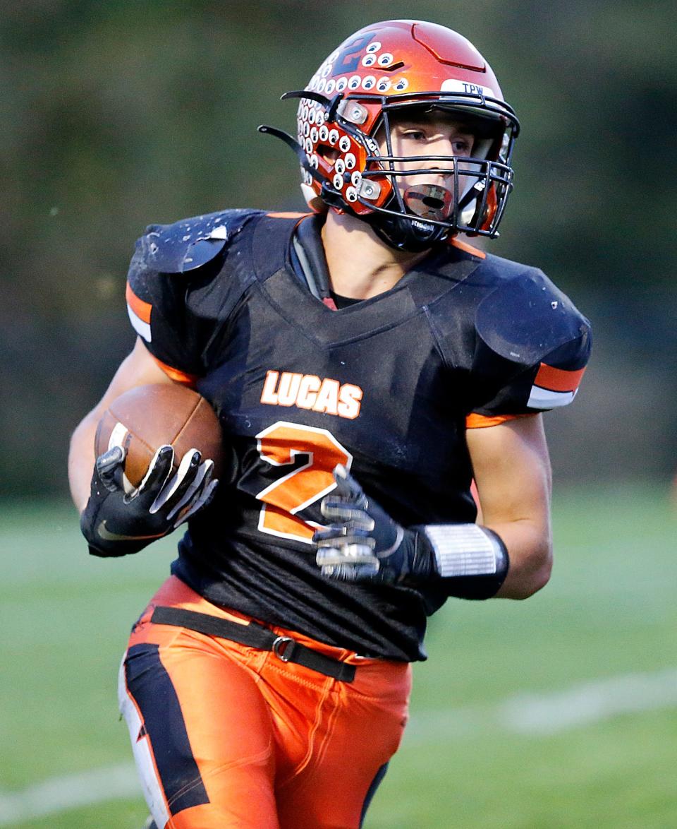 Lucas High School's Logan Toms (2) carries the ball against Plymouth High School during high school football action at Lucas High School Friday, Oct. 6, 2023. TOM E. PUSKAR