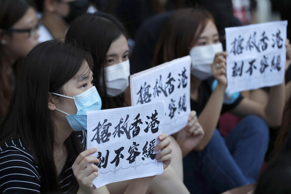 Workers from the medical and health care sector hold up signs that read: "Rescue Hong Kong, There is no time for delay" during a demonstration in Hong Kong on Friday, Aug. 2, 2019. Protesters plan to return to the streets again this weekend, angered by the government's refusal to answer their demands, violent tactics used by police — possibly in coordination with organized crime figures. (AP Photo/Vincent Thian)