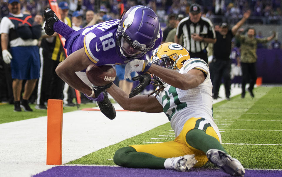 Minnesota Vikings wide receiver Justin Jefferson (18) dives in the end zone for a touchdown over Green Bay Packers cornerback Eric Stokes (21) in the fourth quarter of an NFL football game Sunday, Nov. 21, 2021, in Minneapolis. (Jerry Holt/Star Tribune via AP)