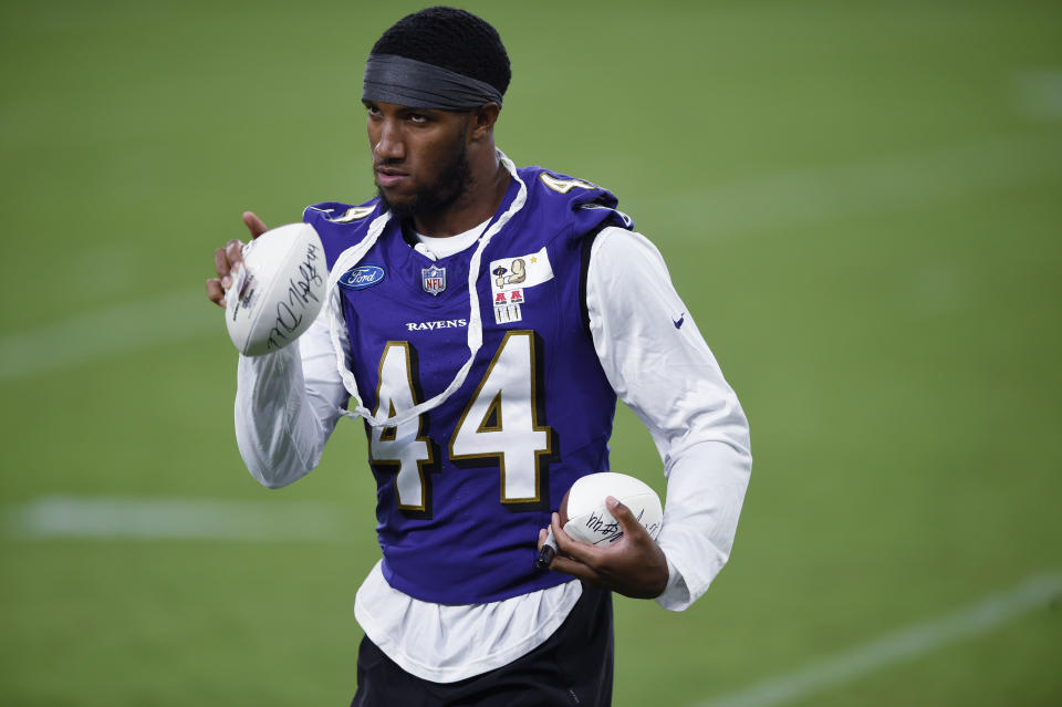 Baltimore Ravens' Marlon Humphreys points to a fan before throwing an autographed football, after practice at NFL football training camp Saturday, July 31, 2021, in Baltimore. (AP Photo/Gail Burton)