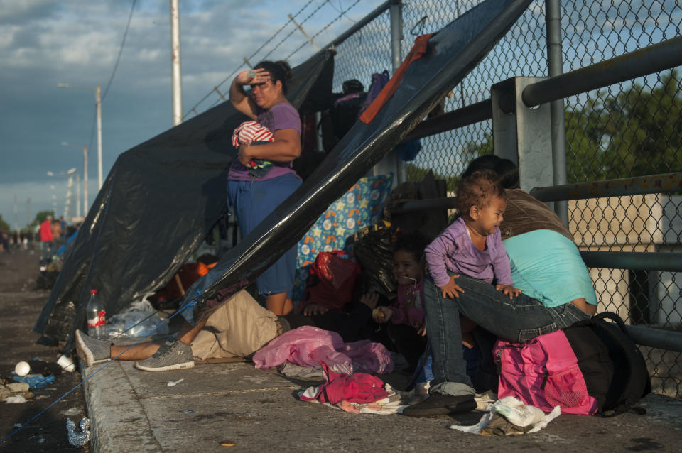 Migrantes hondureños esperan entrar a México sobre un puente fronterizo, en Tecún Umán, Guatemala, el domingo 21 de octubre de 2018. (AP Foto/Oliver de Ros)