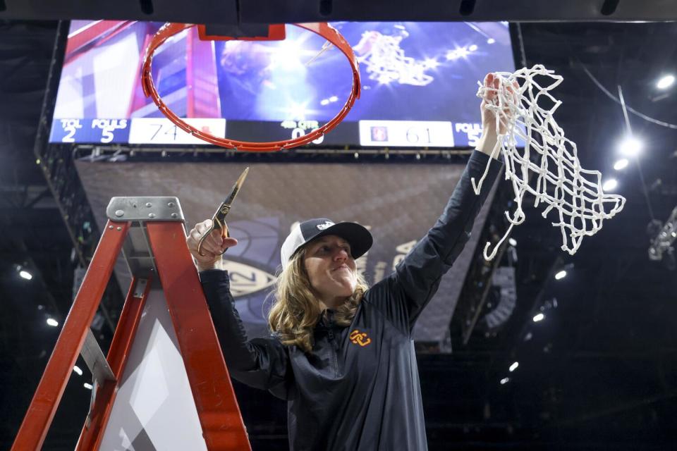 USC coach Lindsay Gottlieb celebrates after cutting down the net following the Trojans' victory.