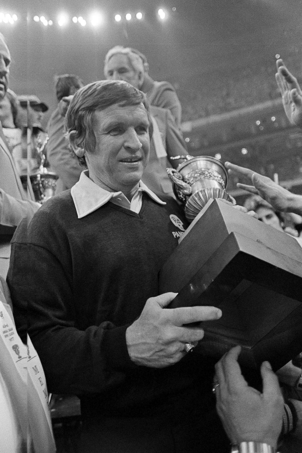 FILE - In this Jan. 3, 1977, file photo, University of Pittsburgh coach Johnny Majors carries the Sugar Bowl trophy after Pittsburgh beat Georgia 27-3 to win the NCAA college football national championship, in New Orleans. Majors, the coach of Pittsburgh’s 1976 national championship team and a former coach and star player at Tennessee, has died. He was 85. Majors died Wednesday morning, June 3, 2020, at home in Knoxville, Tenn., according to a statement from his wife, Mary Lynn Majors. (AP Photo/File)