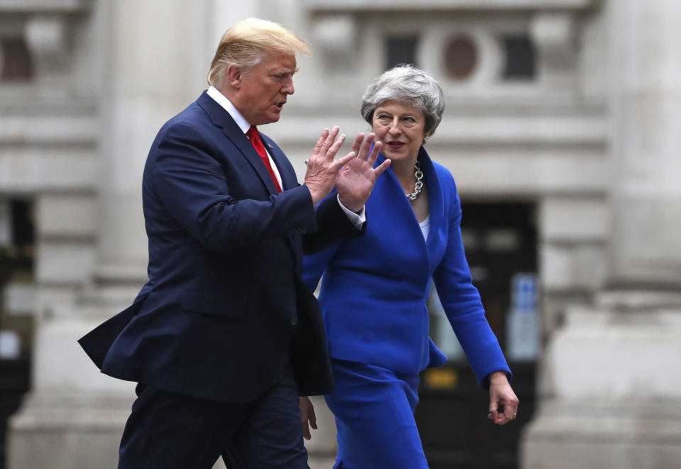 Britain's Prime Minister Theresa Mayand President Donald Trump walk through the Quadrangle of the Foreign Office for a joint press conference in central London, Tuesday, June 4, 2019. (AP Photo/Frank Augstein)