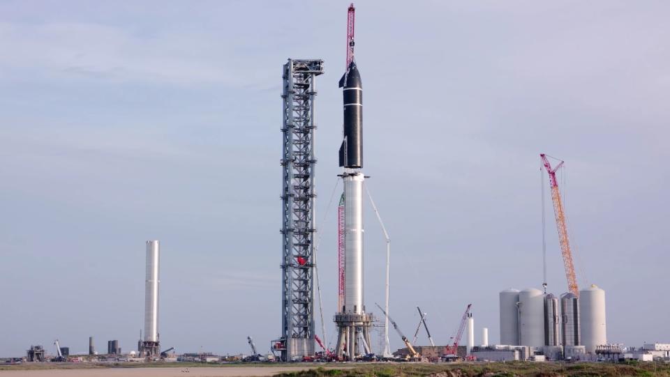 A crane lowers the top stage of SpaceX's starship onto its bottom stage at SpaceX's "Starbase" in Texas.