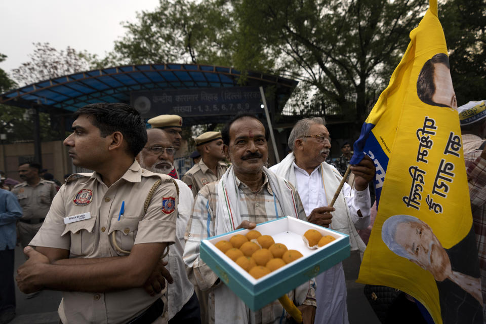 A supporter of the Aam Aadmi Party distributes sweets as he waits with others for the release of the party leader Arvind Kejriwal from Tihar Jail in New Delhi, India, Friday, May 10, 2024. The Supreme Court ordered Arvind Kejriwal's temporary release enabling him to campaign in the country's national election until the voting ends on June 1. (AP Photo /Altaf Qadri)