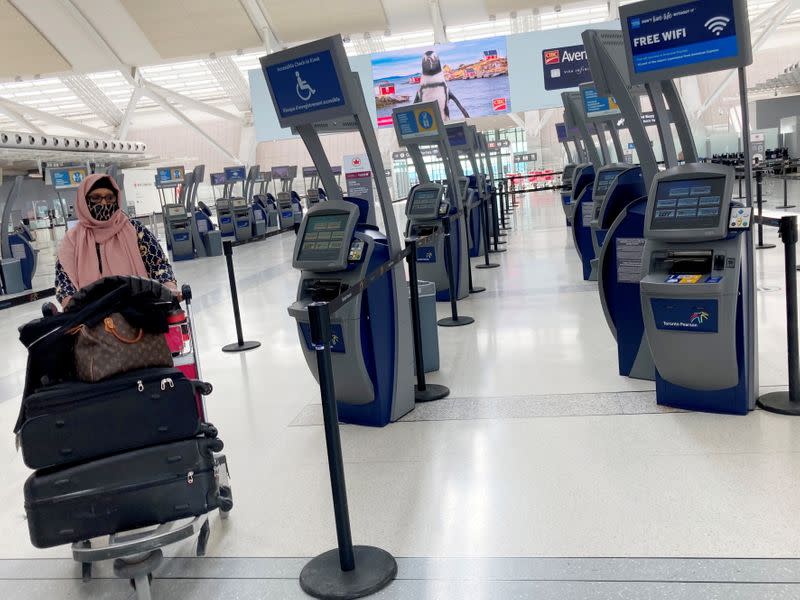 A woman wheels her luggage at Toronto Pearson International Airport in Mississauga