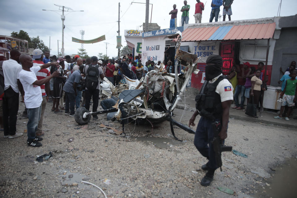 Police guard the crash site of a small plane in the community of Carrefour, Port-au-Prince, Haiti, Wednesday, April 20, 2022. Authorities report that the plane was headed to the southern coastal city of Jacmel when it tried to land in Carrefour, and that at least 5 people died in the accident. (AP Photo/Odelyn Joseph)