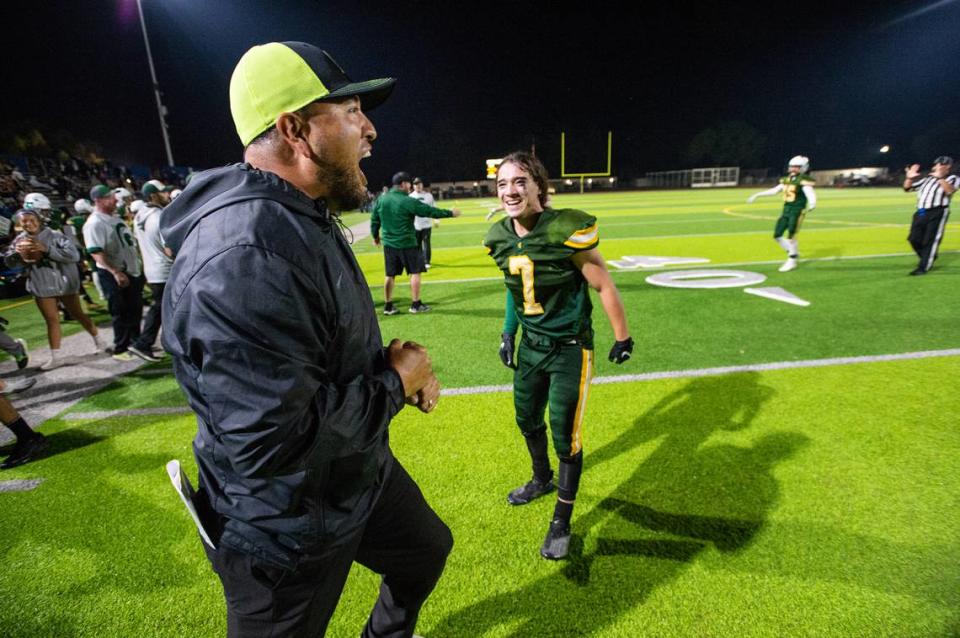 Davis coach Tim Garcia, left, and player Jordan Mendoza (7) celebrate their 33-24 victory over Ceres in the Western Athletic Conference game at Downey High School in Modesto, Calif., on Thursday, Oct. 28, 2021. Andy Alfaro/aalfaro@modbee.com