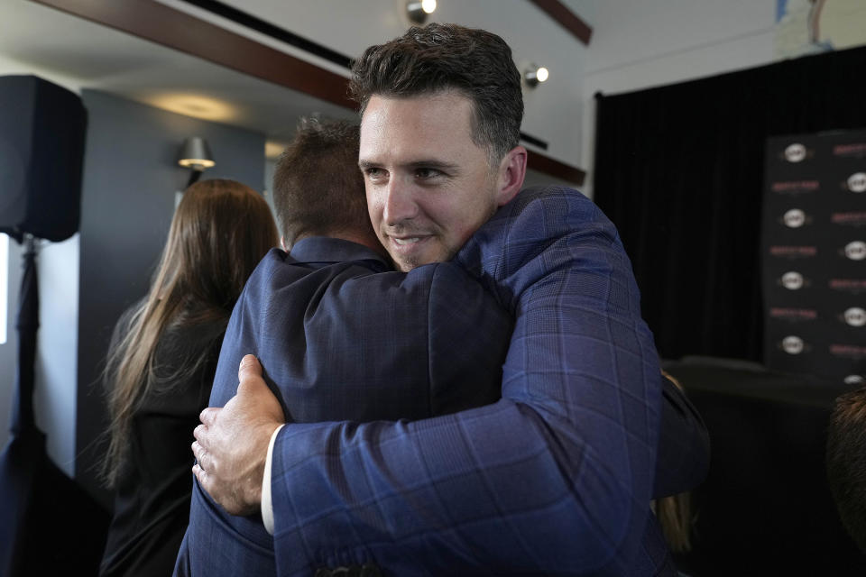 San Francisco Giants catcher Buster Posey hugs a friend after a news conference announcing his retirement from baseball, Thursday, Nov. 4, 2021, in San Francisco. (AP Photo/Tony Avelar)