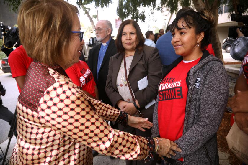 SANTA MONICA, CA - OCTOBER 23, 2023 - State Senator Maria Elena Durazo, left, confers with Norelis Vargas, right, from Venezuela, along with Angelica Salas, center, Executive Director of CHIRLA, after a press conference to address the allegation that refugee workers are using a dodgy agency to provide houseless strikebreakers to work at Le Meridien Defina hotel in Santa Monica on October 23, 2023. Vargas was hired as a temporary worker at the Four Points Hotel near LAX and currently lives at the Union Rescue Mission. (Genaro Molina / Los Angeles Times)