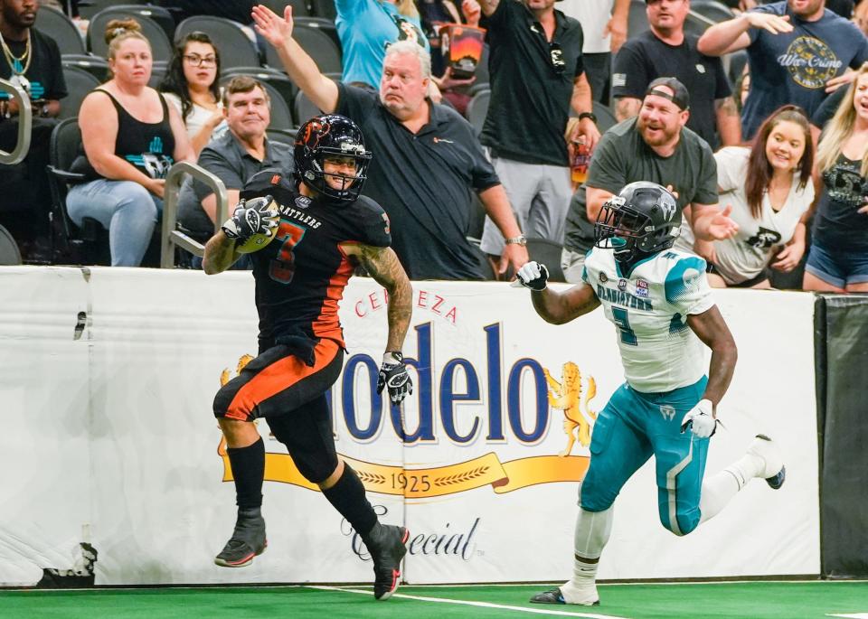 July 24, 2022; Phoenix, Ariz., U.S.; Arizona Rattlers running back Shannon Brooks (3) runs past Duke City Gladiators defensive back Roderick Chapman (3) during the first half of the Indoor Football League playoffs at the Footprint Center in Phoenix on July 24, 2022. Mandatory Credit: Samantha Chow/The Republic