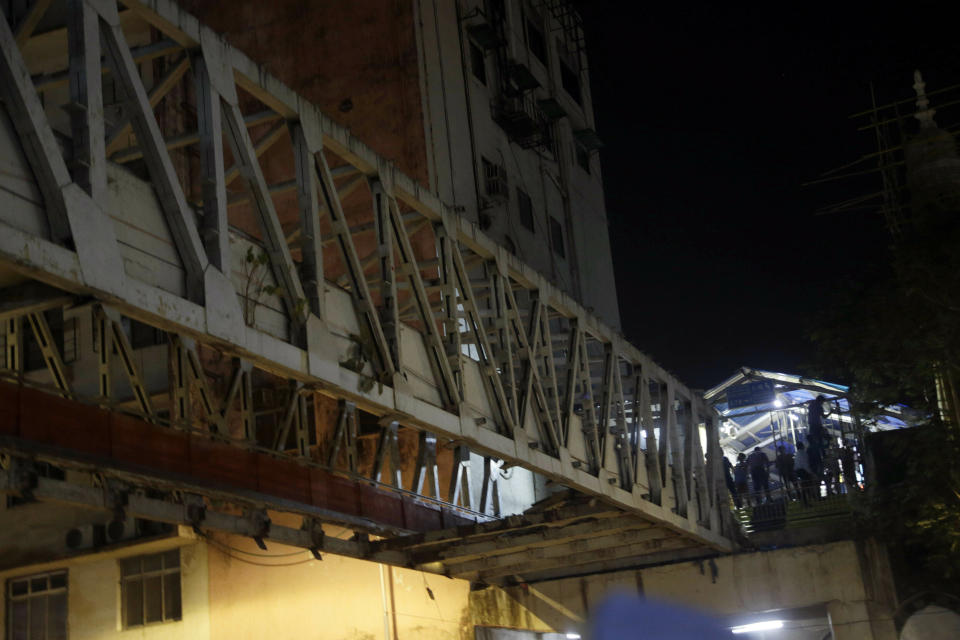 A pedestrian bridge stands hollow after parts of it collapsed in Mumbai, India, Thursday, March 14, 2019. A pedestrian bridge connecting a train station with a road collapsed in Mumbai on Thursday, killing at least five people and injuring more than 30, police said. (AP Photo/Rajanish Kakade)