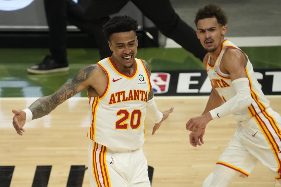 Atlanta Hawks' John Collins reacts after a dunk assisted by Trae Young during the second half of Game 1 of the NBA Eastern Conference basketball finals game against the Milwaukee Bucks Wednesday, June 23, 2021, in Milwaukee. (AP Photo/Morry Gash)