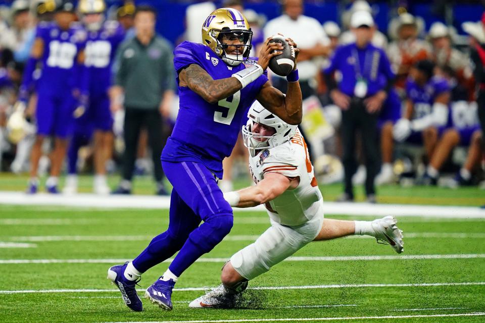 Washington quarterback Michael Penix Jr. (9) avoids the pressure of Texas defensive end Ethan Burke (91) during their College Football Playoff semifinal game at the 2024 Sugar Bowl.