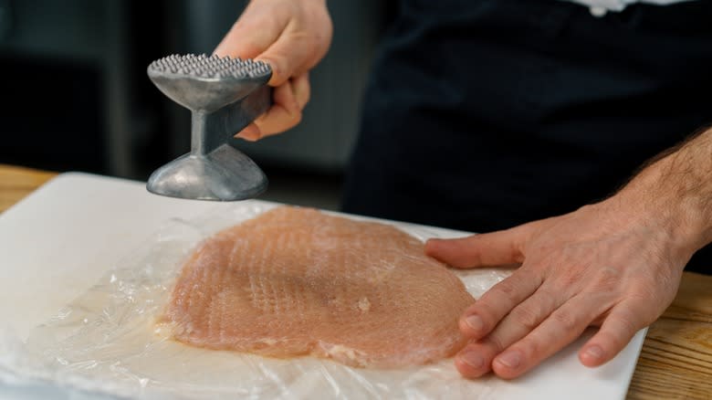 Meat mallet being used on chicken 