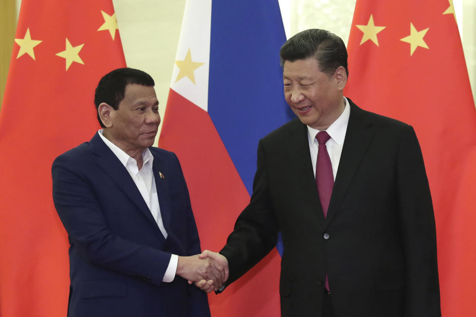 FILE - In this April 25, 2019, file photo, Philippine President Rodrigo Duterte, left, shakes hands with Chinese President Xi Jinping, right, before their meeting at the Great Hall of People in Beijing. Duterte raised his nation’s concerns over territorial disputes in the South China Sea at a meeting with Chinese President Xi Jinping in Beijing that followed the signing of multi-billion dollar trade agreements. (Kenzaburo Fukuhara/Pool Photo via AP)